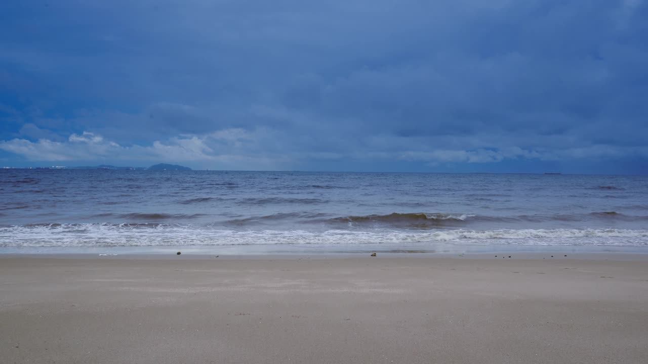 雨季的热带沙滩与黑云白沙异域热带沙滩，观看海浪在热带白沙海滩上破浪。视频素材