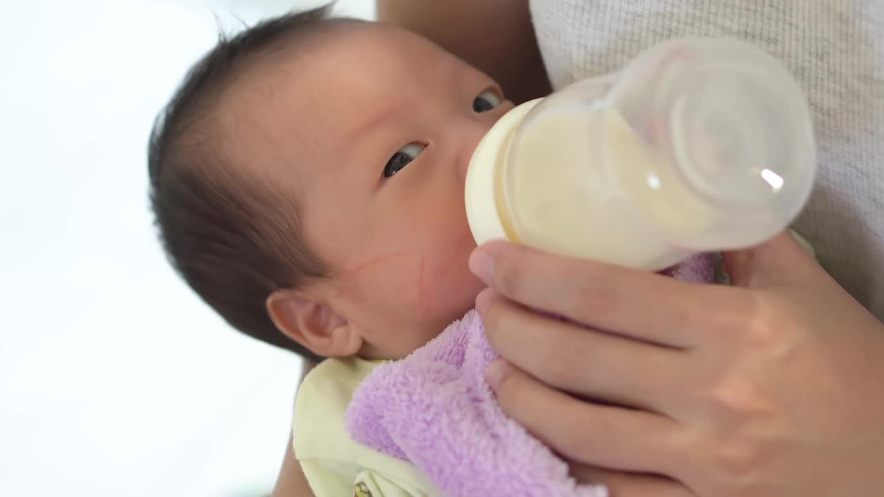 新生儿用奶瓶喝牛奶视频素材