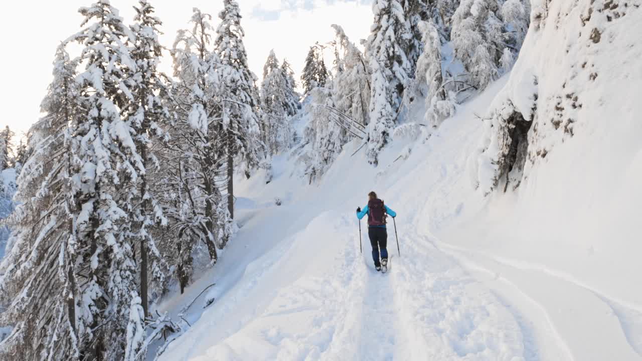 在雪道上行走的女性徒步旅行者视频素材