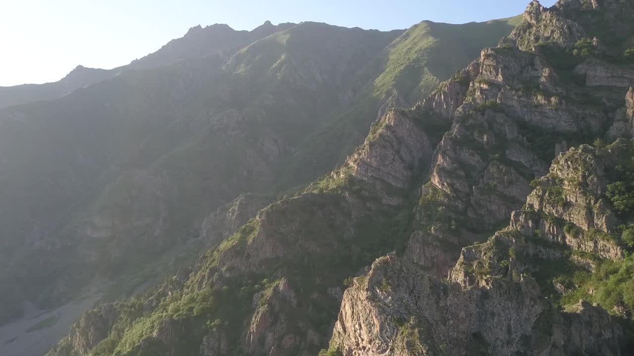 四轴飞行器在高加索山脉的岩石残骸上飞行，被早晨的阳光照亮。亚美尼亚风景如画的峡谷和峡谷视频素材