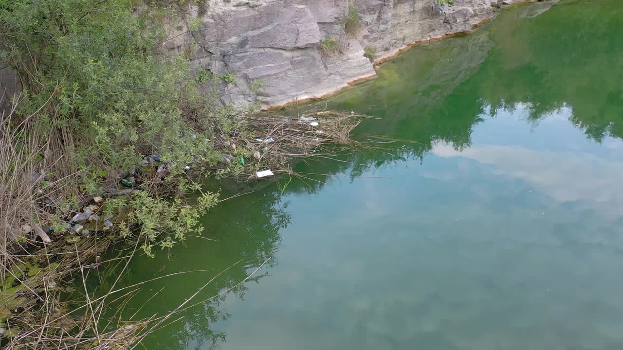 在采石场的水中漂浮着垃圾。污染视频素材