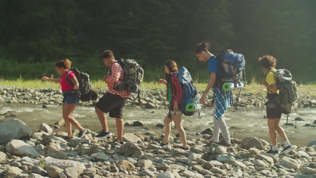 积极多样的多民族徒步旅行者背着背包在山上徒步旅行视频素材