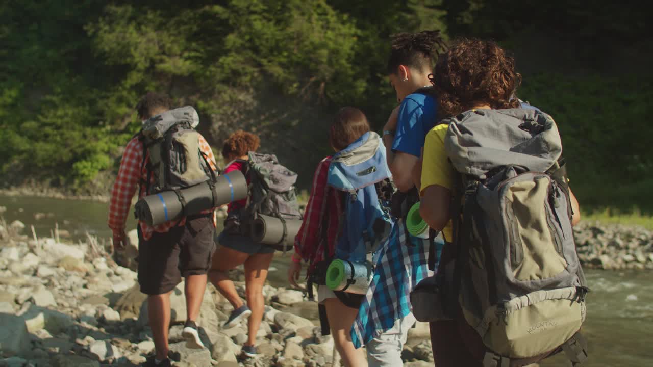 多种族的游客背对着背包在山间河流边背包旅行视频素材