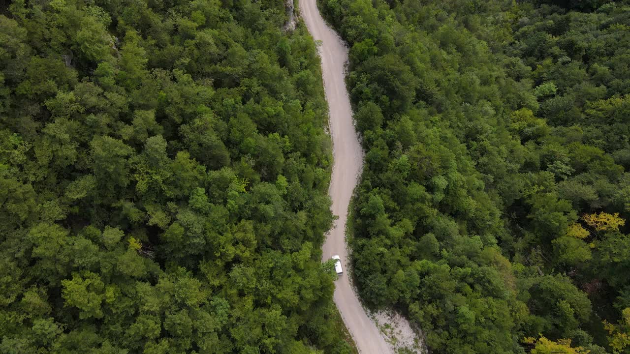 无人机视角的汽车驾驶在乡村道路上的丘陵视频素材