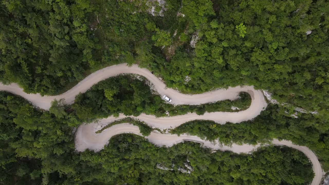 从一辆停在蜿蜒的乡村公路上的车的正上方放大视频素材