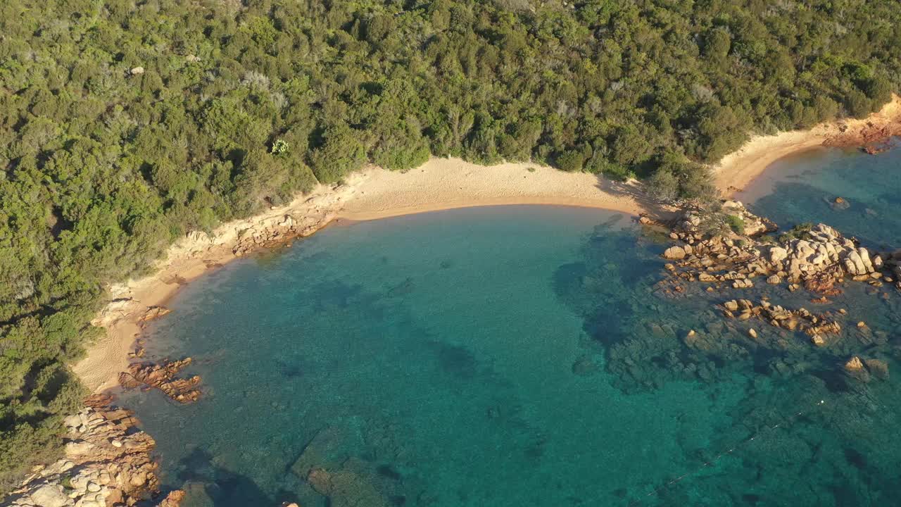 从上面看，令人惊叹的鸟瞰绿色的海岸线，一些海滩沐浴在一个美丽的日出碧海。Liscia Ruja, Costa meralda，意大利撒丁岛。视频素材