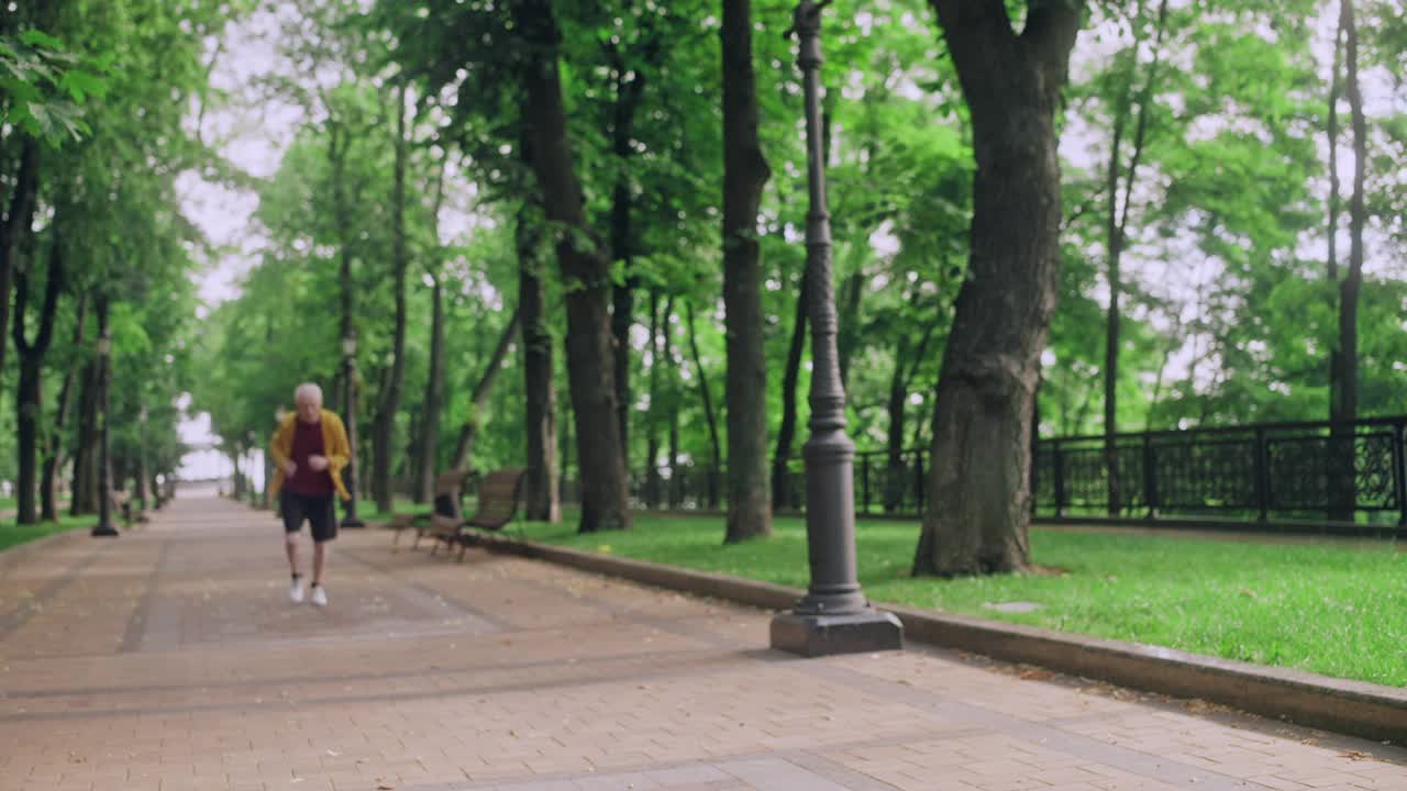 成熟的男人早上在公园跑步，休息一下喘口气，锻炼身体视频素材