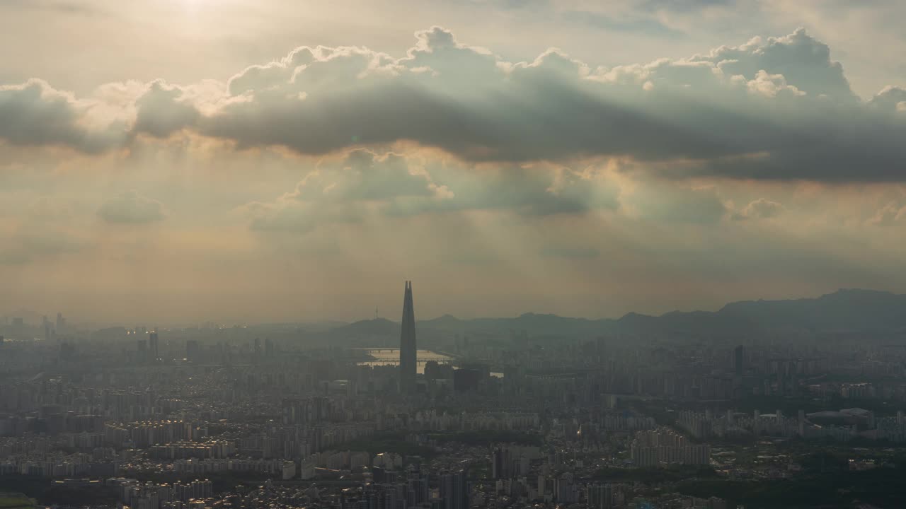 白天从首尔松坡区南汉山城看，蚕室区乐天世界塔周围的市中心的廷德尔现象视频素材