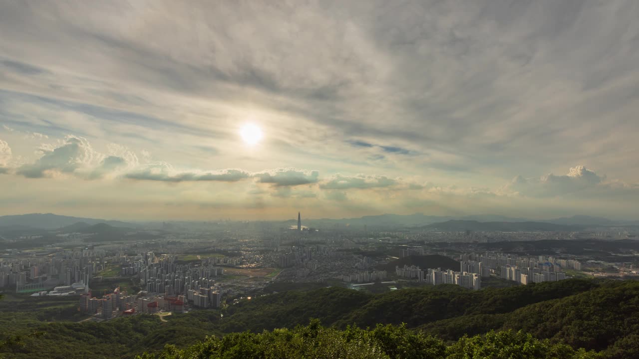 从首尔松坡区南汉山城看日落时，蚕室区乐天世界塔周围的市中心云朵从白天到晚上的景色视频素材