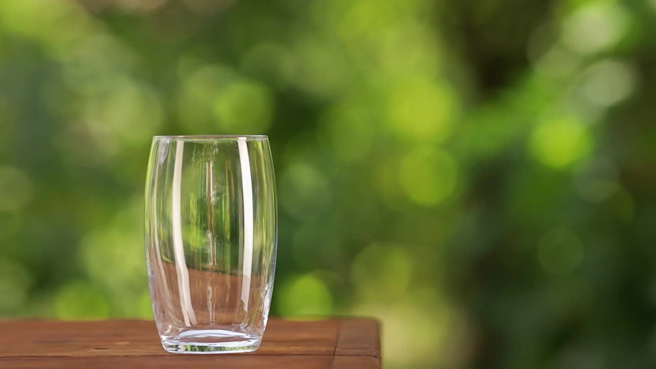 把水壶里的水倒进玻璃杯里视频素材