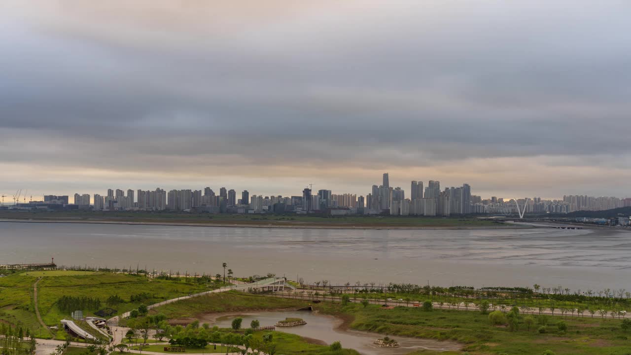 在台风和晚霞阵雨的影响下，京畿始兴市培果新城市培果生命公园和松岛国际商圈附近的市中心白天到晚上的景色视频素材