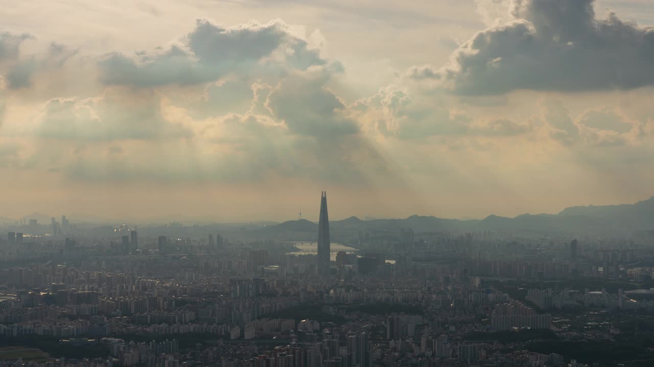 白天从首尔松坡区南汉山城看，蚕室区乐天世界塔周围的市中心的廷德尔现象视频素材