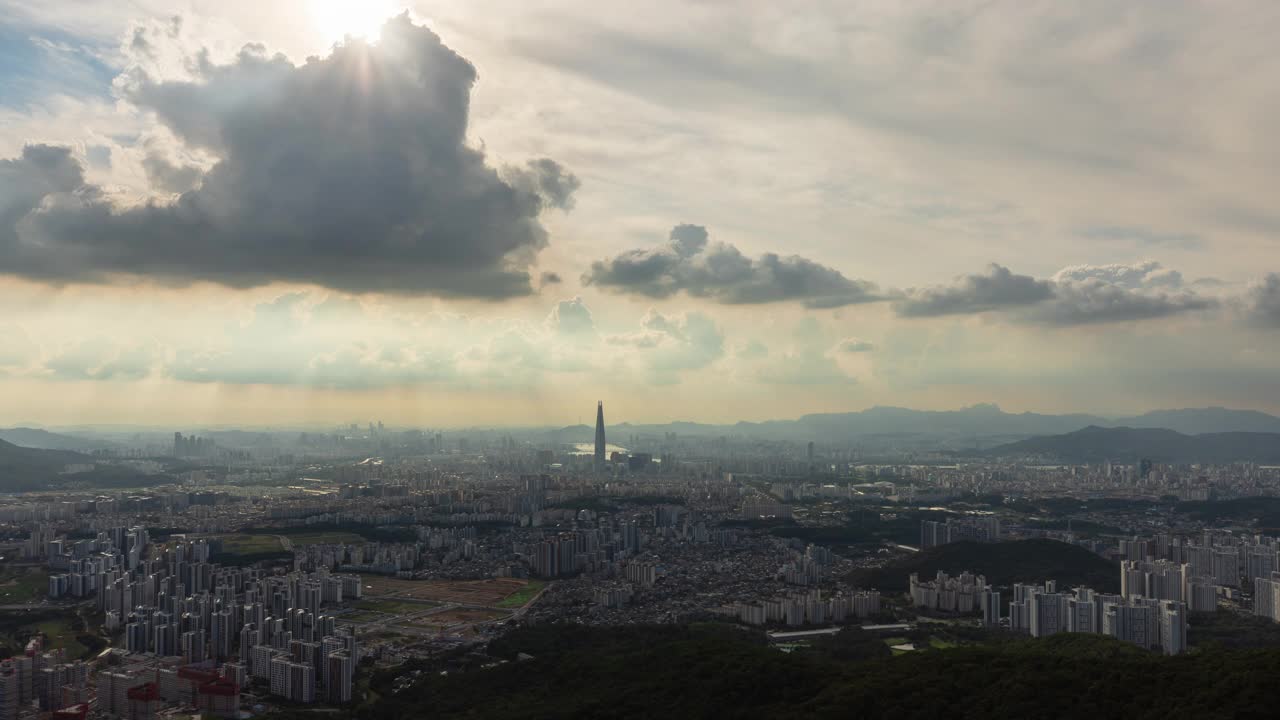 白天从首尔松坡区南汉山城看，蚕室区乐天世界塔周围的市中心的廷德尔现象视频素材