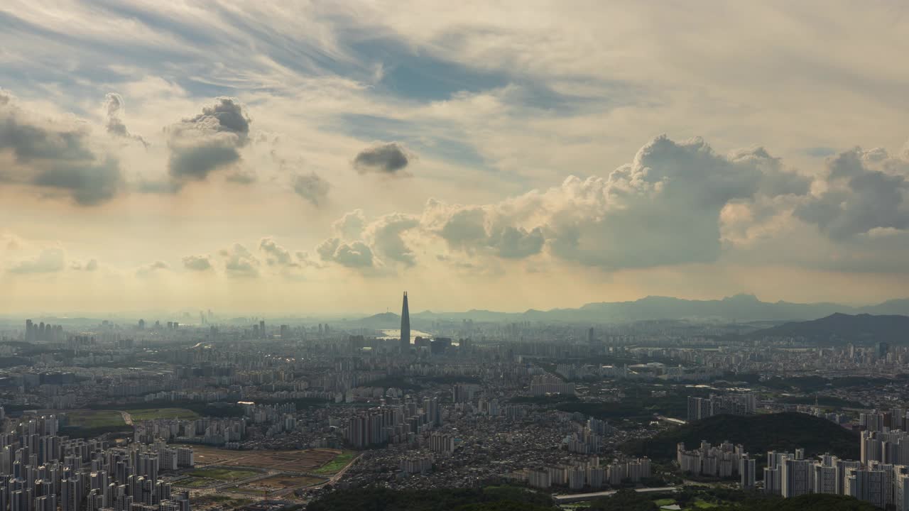 白天从首尔松坡区南汉山城看，蚕室区乐天世界塔周围的市中心的廷德尔现象视频素材