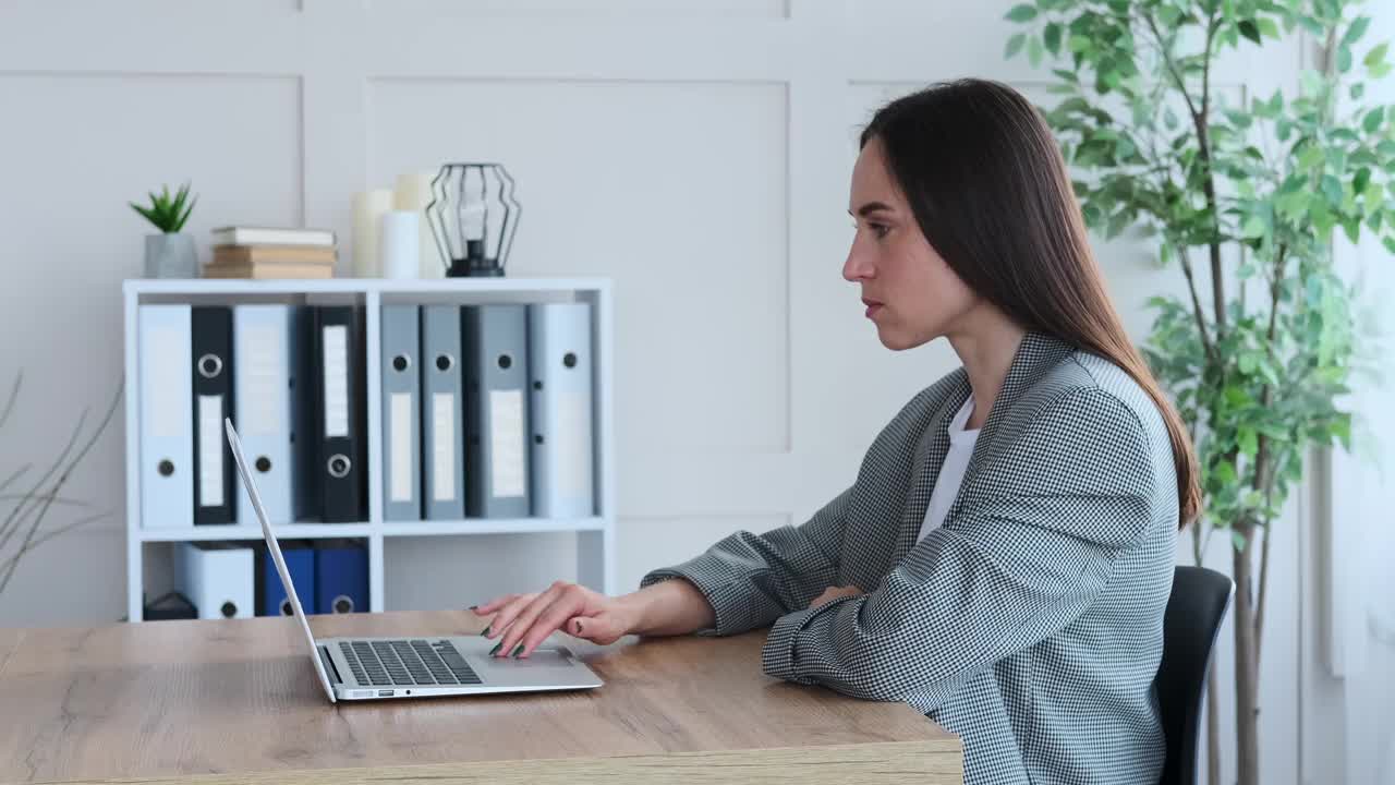 女商人在办公室用笔记本电脑收到积极的消息视频素材