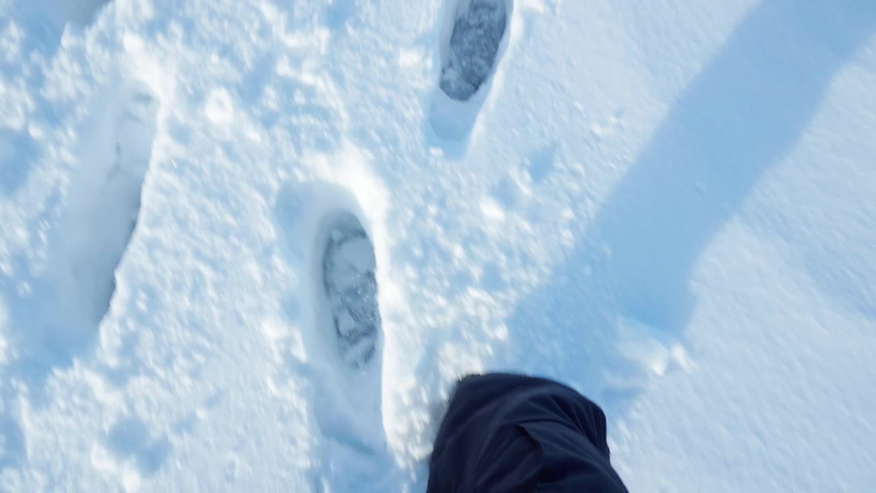 脚在雪地里走着。游客在雪地上徒步冬雪之旅。视频素材