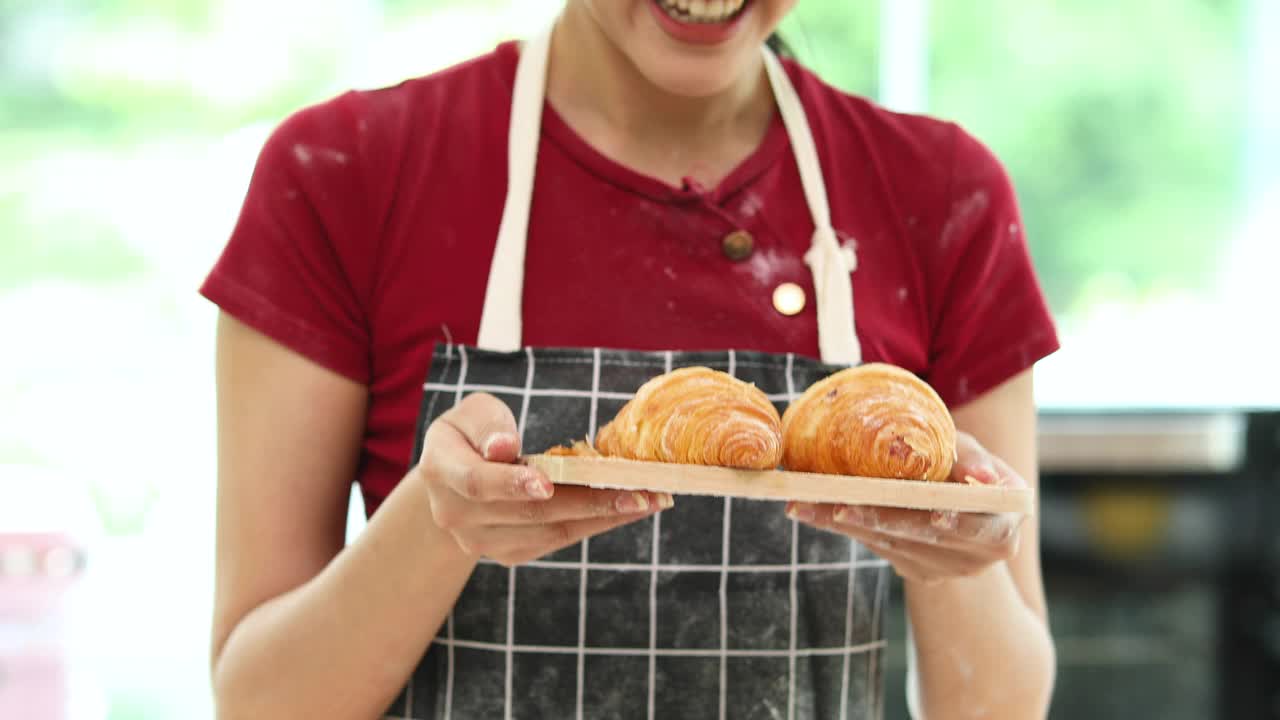 有吸引力的年轻亚洲女人在厨房做饭。视频素材