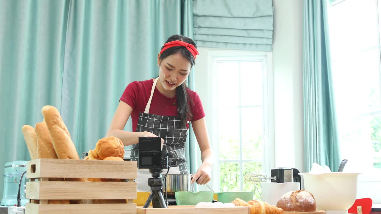 有吸引力的年轻亚洲女人在厨房做饭。视频素材