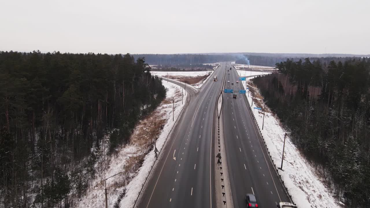 宽阔的郊区高速公路上有快速移动的卡车和汽车在冬天，鸟瞰图。视频素材