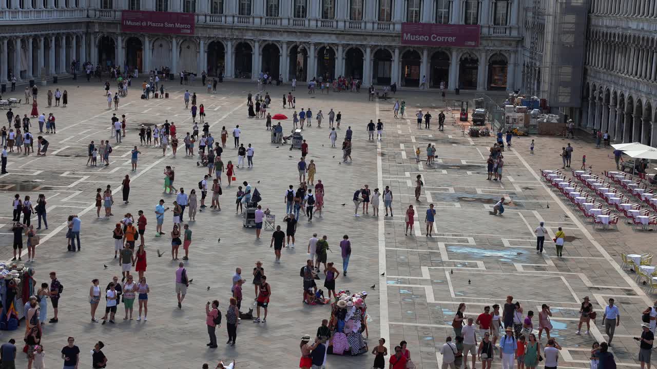 在一个阳光明媚的夏日，人们在威尼斯圣马可广场散步。视频素材