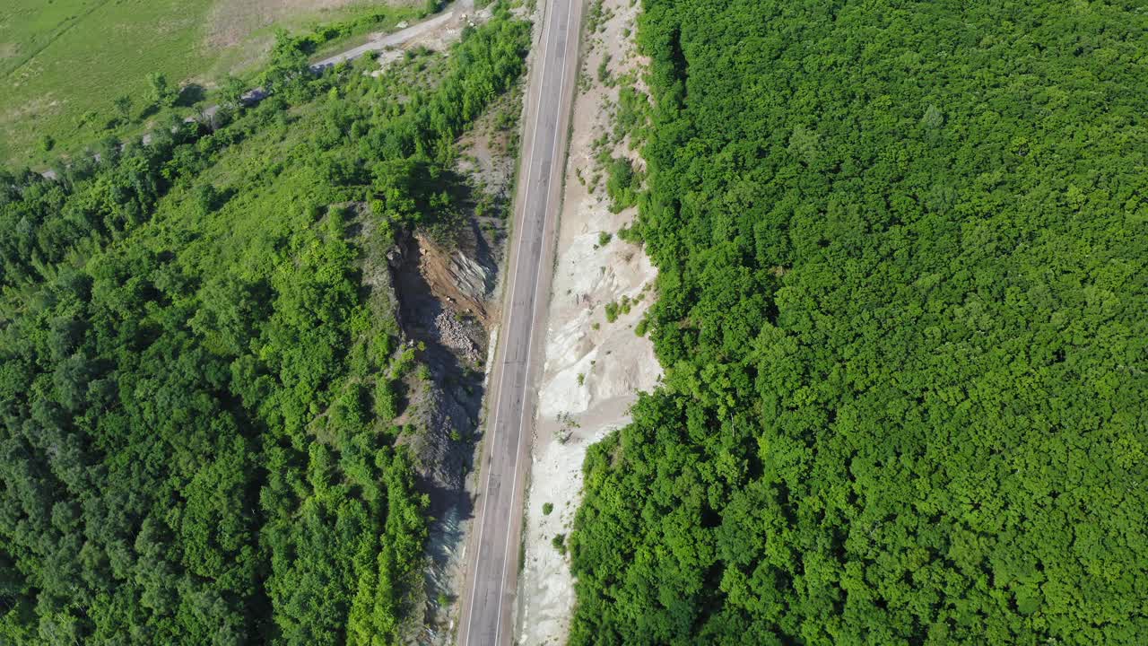 一辆白色汽车在乡村道路上垂直向下的鸟瞰图视频素材