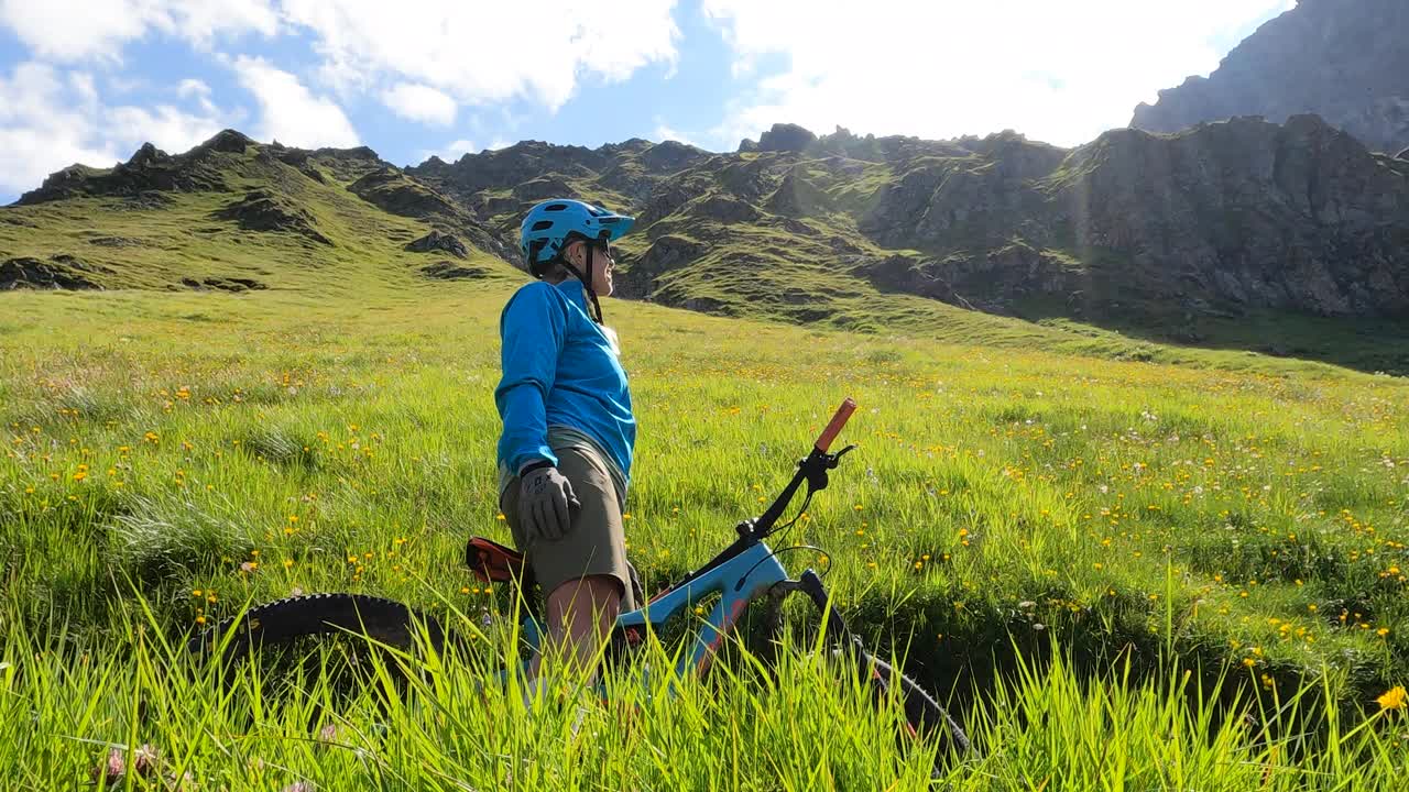 一名女山地自行车手在山路上停下来视频素材