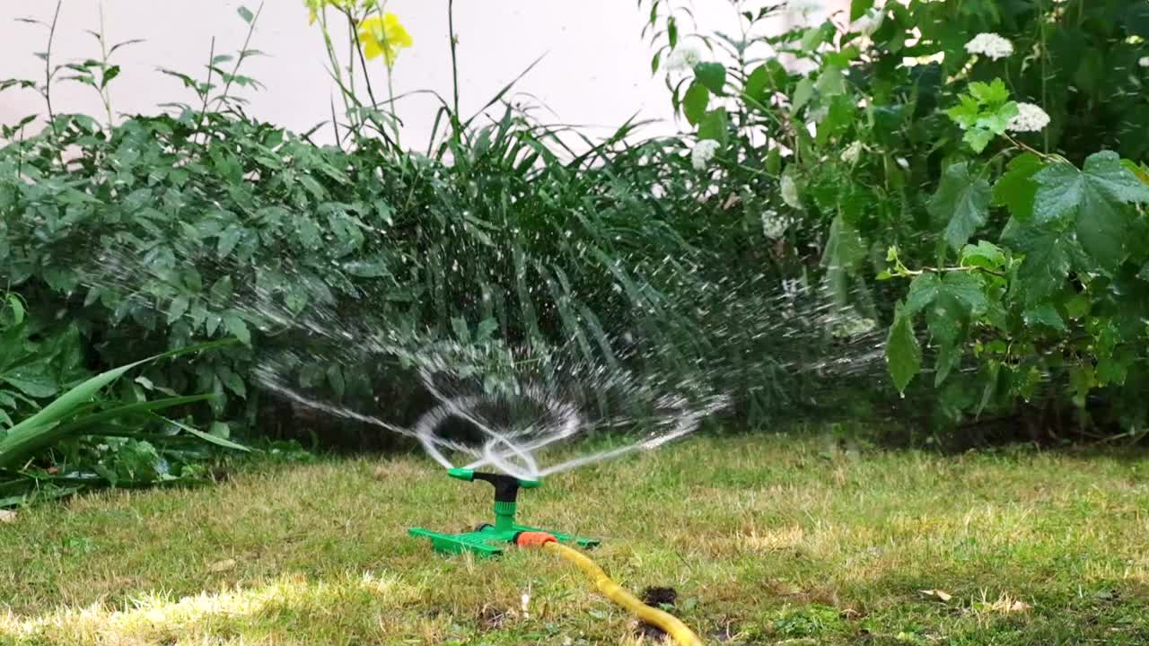 草坪自动洒水器可以恢复和浇灌花园。缓慢的运动。园艺护理概念，园艺，自动园艺设备视频素材