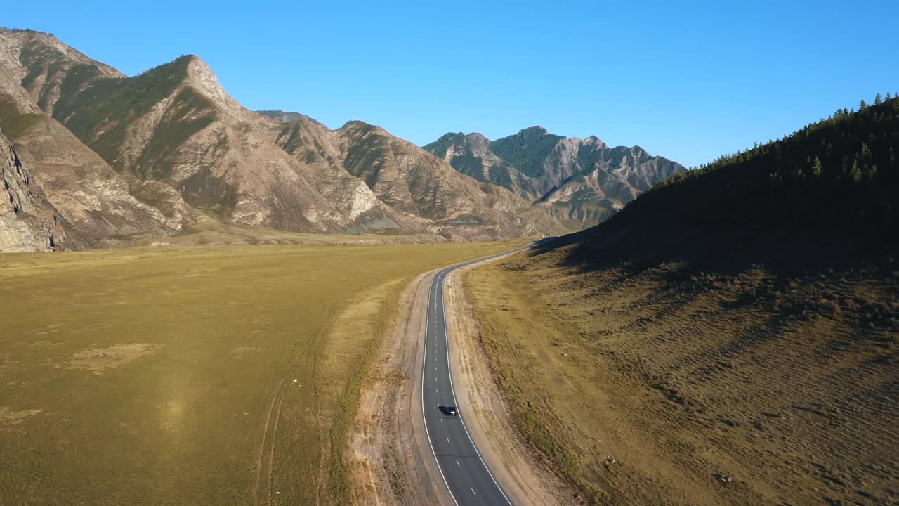 汽车行驶在沥青公路背景落基山脉在夏天的一天视频素材