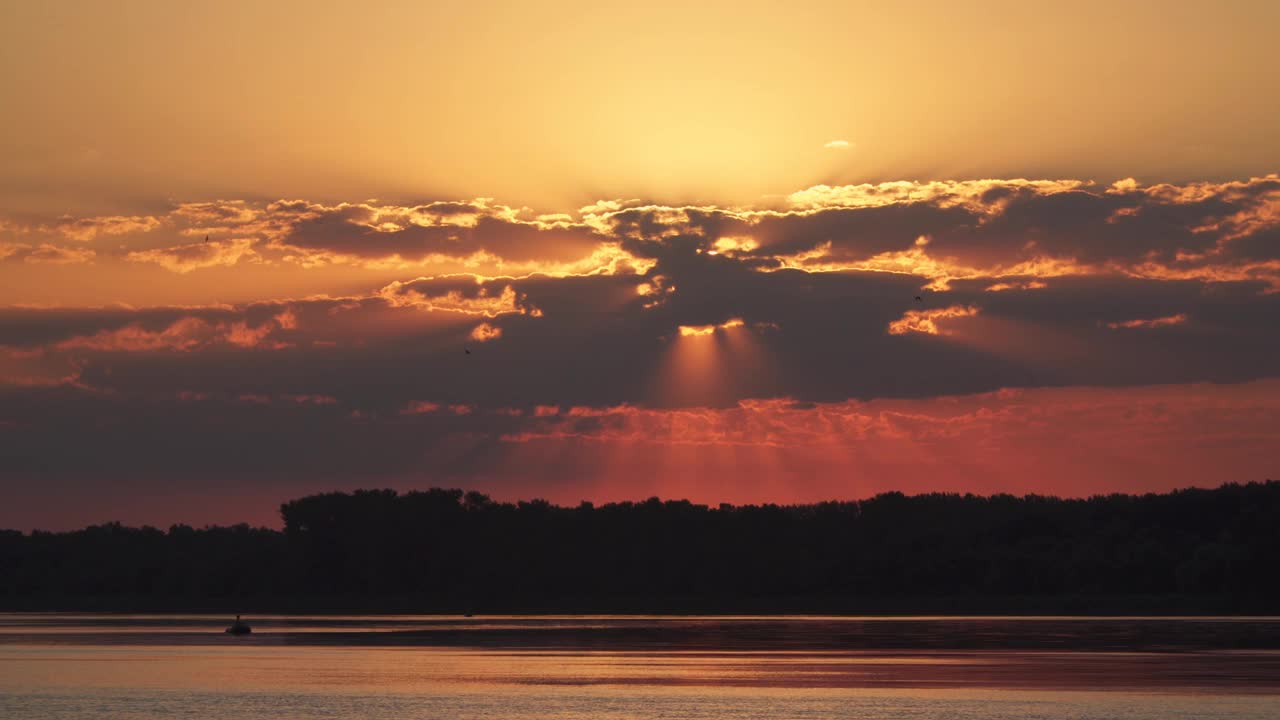 河上的夕阳。在河上你可以看到一个渔夫在船上。视频素材