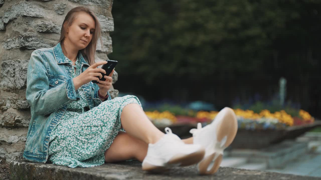 带着智能手机的女人在老城区休息。视频素材