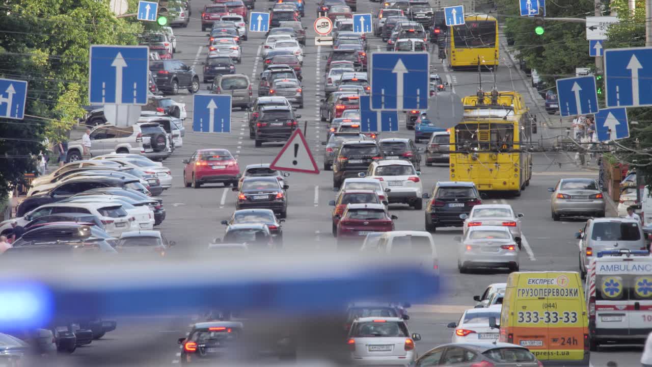 闪烁的警灯警笛警车街道交通在大城市的背景。巡逻警灯汽车道路繁忙的城市一天。警用巡逻车闪烁着蓝色的警灯，拥挤的大街上交通拥堵视频素材