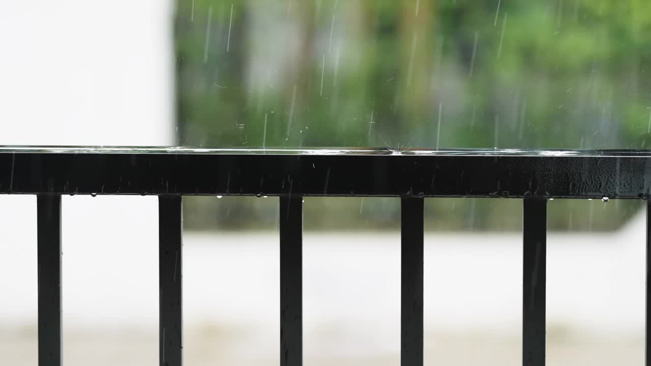 暴风雨打在房子前面的黑色篱笆上视频素材