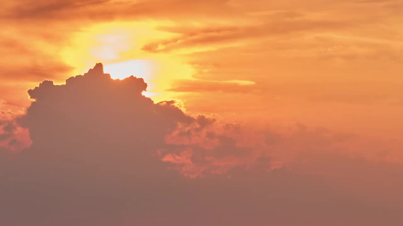 炽热的红日在晚霞的轮廓后面，时间流逝。夏日夕阳在天空中朦胧，时光流逝视频素材