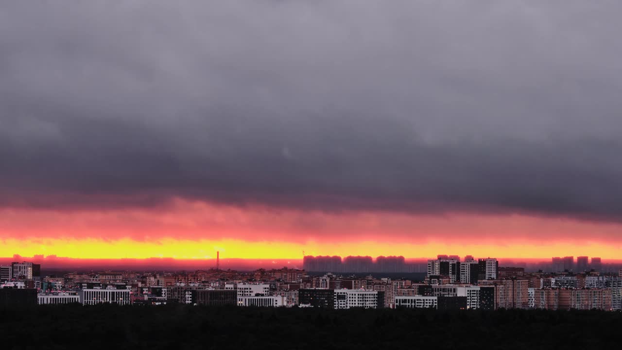 火红的太阳在城市建筑的轮廓后面，时间流逝。夏日的夕阳在天空中阴霾着夜屋，时光流逝视频素材