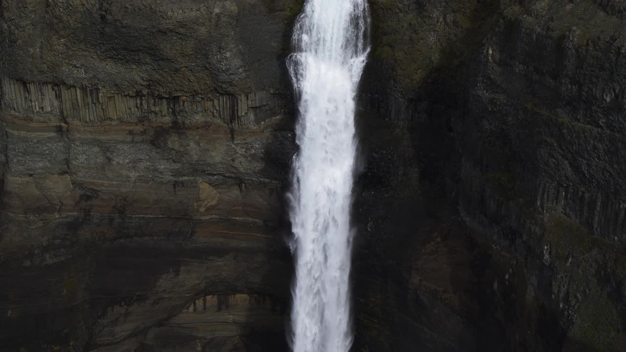 冰岛高地瀑布飞溅在岩石上的慢动作鸟瞰图视频素材