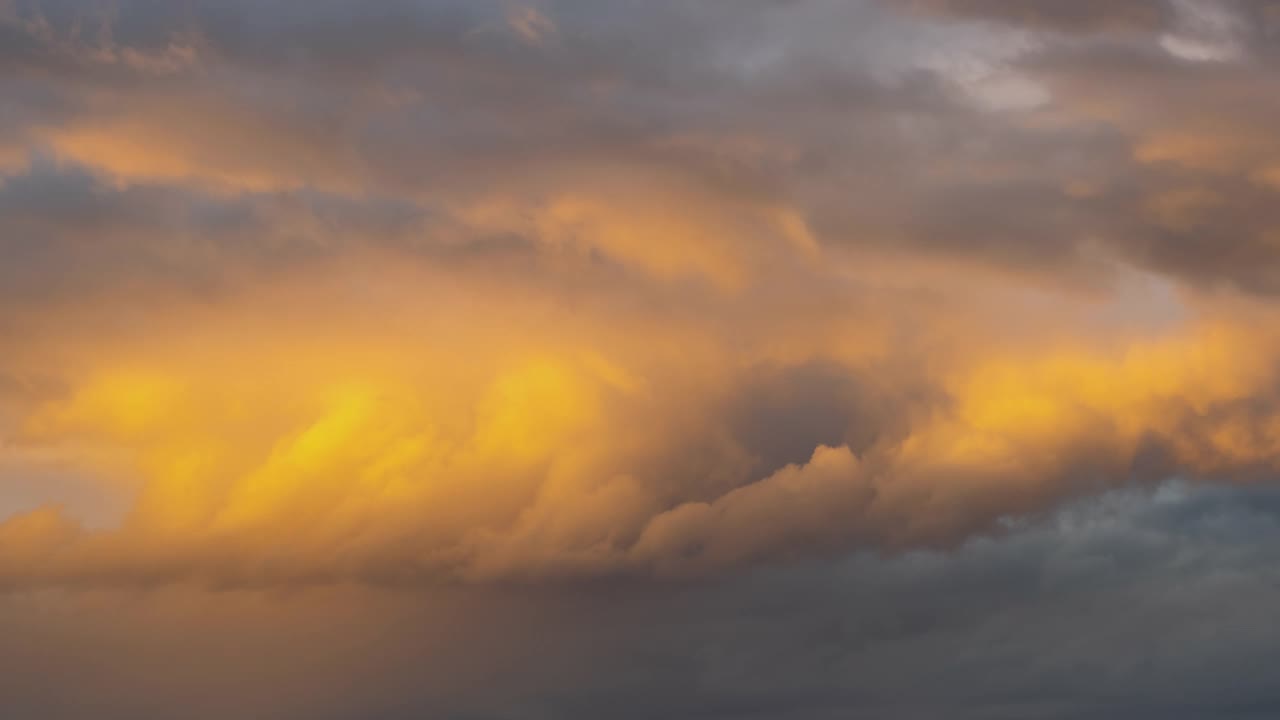 日落时，暗黄色天空上快速移动的暴风雨云的时间流逝。视频素材