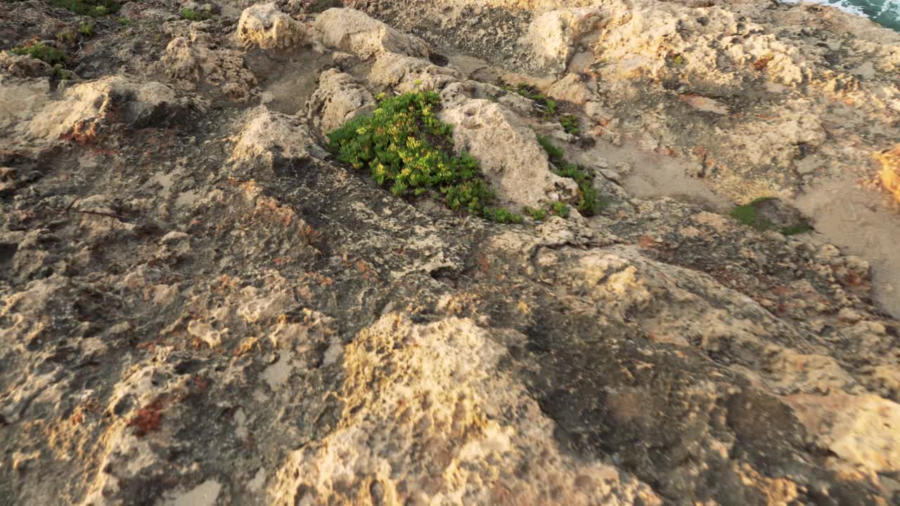 走到岩石悬崖的尽头，看到海浪拍打着岩石视频素材