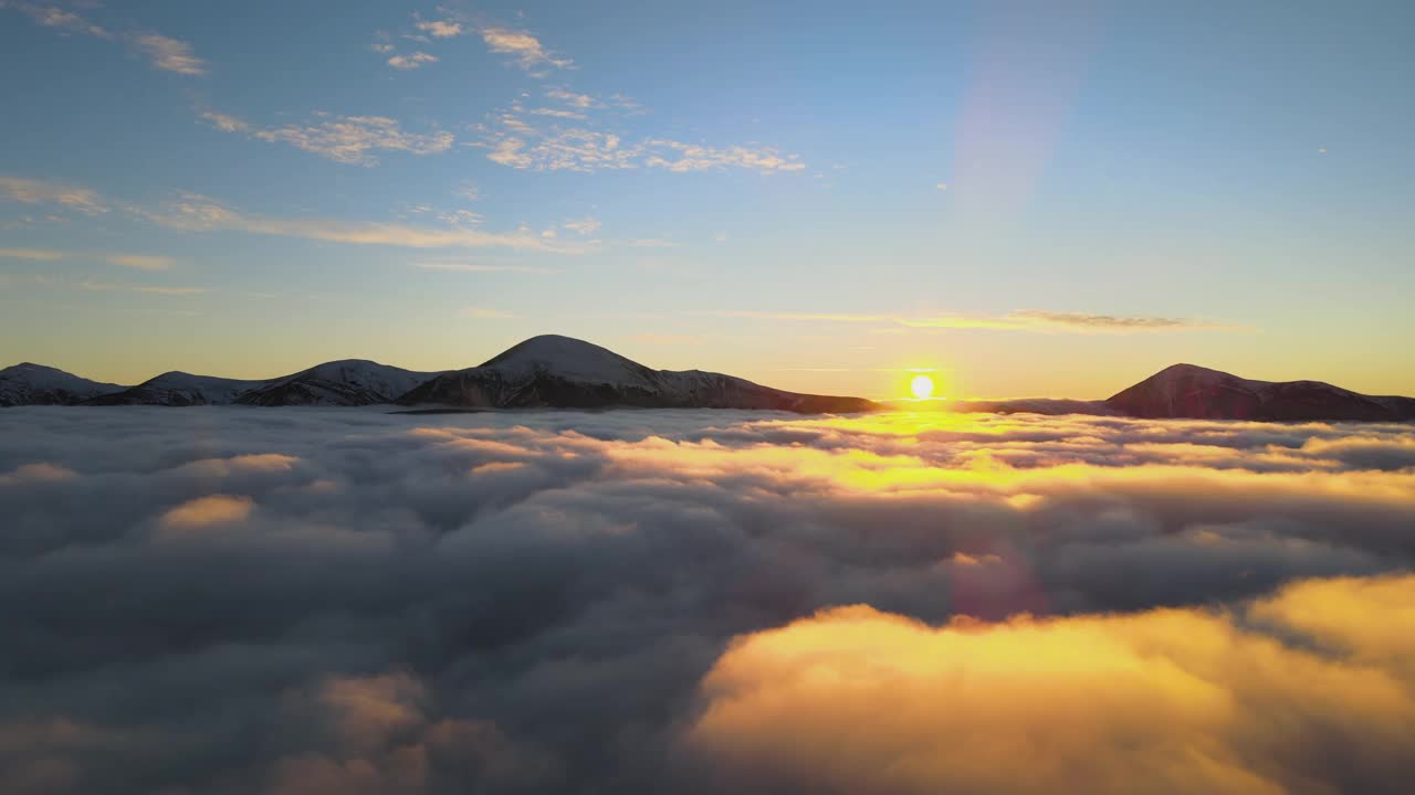 鸟瞰生机勃勃的日出在白色的浓雾与遥远的喀尔巴阡山脉的黑暗山峰在地平线上。视频素材