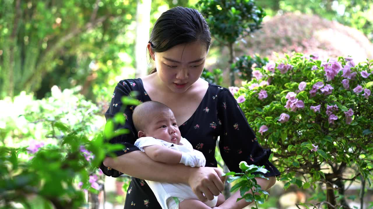 亚洲母亲在后院抱着她的男婴视频素材