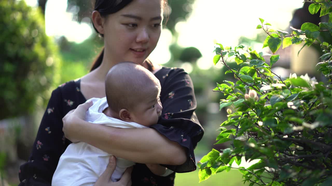 亚洲母亲在后院抱着她的男婴视频素材