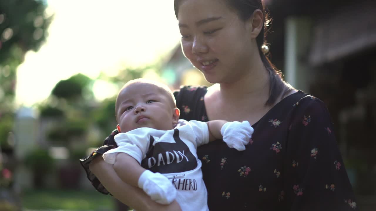 亚洲母亲在后院抱着她的男婴视频素材