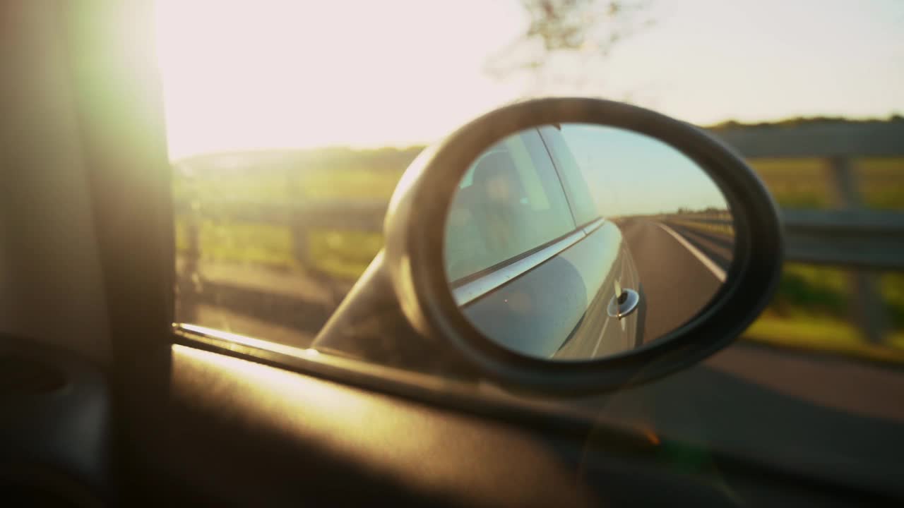 在日落时驾驶后视镜，道路交通，高速公路上的Pov跟踪车，自动窗口视图视频素材