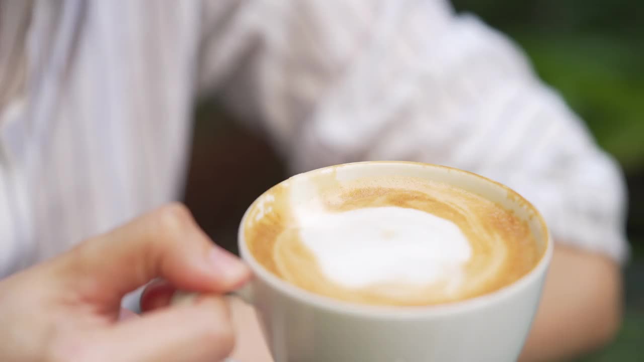 4K特写:亚洲女人在咖啡馆用咖啡杯喝咖啡视频素材