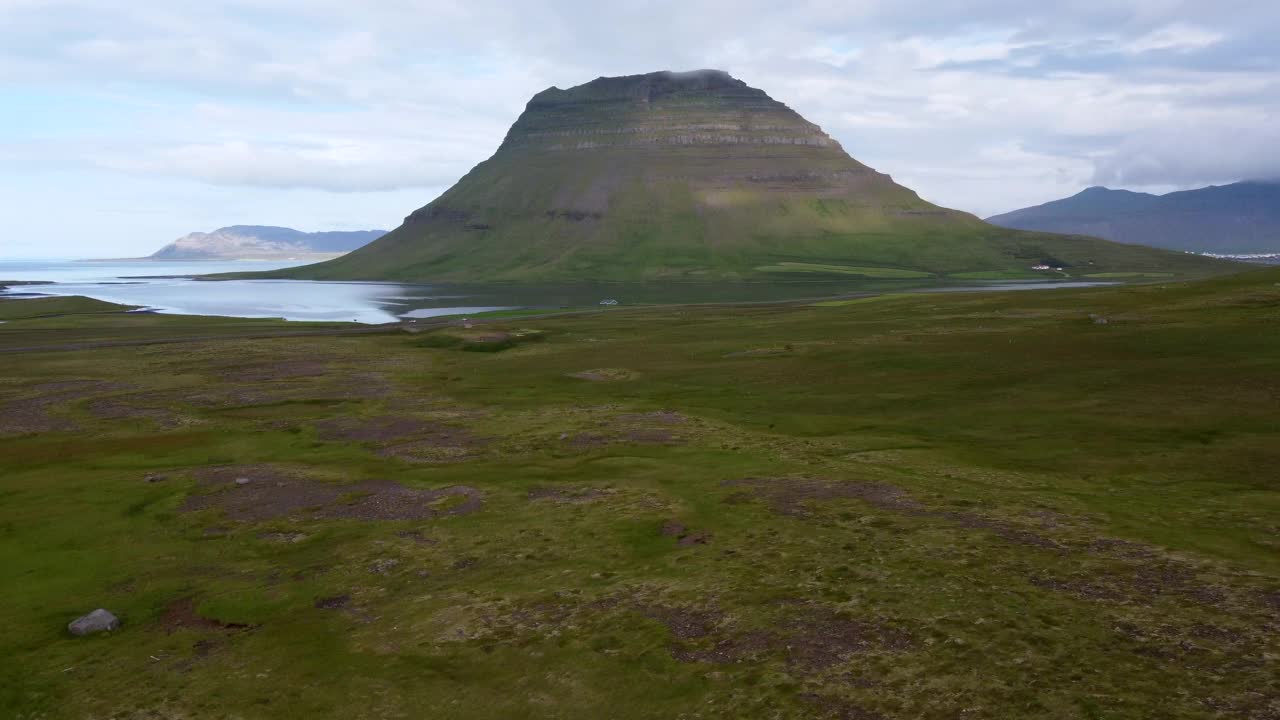 绿草如茵的景观，朝向Kirkjufell峰，海水环绕的海湾视频素材