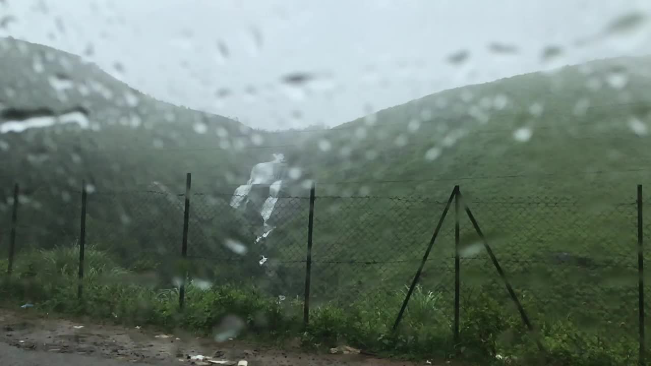 从汽车上拍摄的雨天山上瀑布的景象视频下载