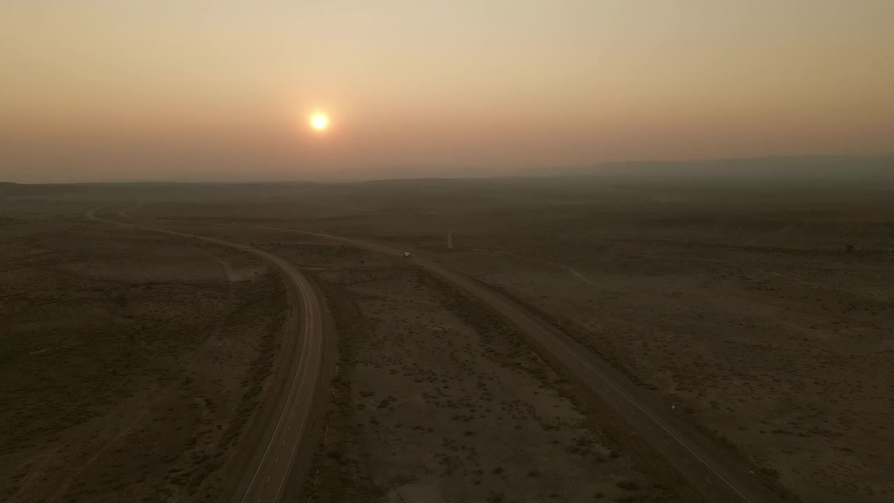 空中POV日落货物运输长途半挂车在美国西部州际公路上的乡村慢动作和实时视频视频素材