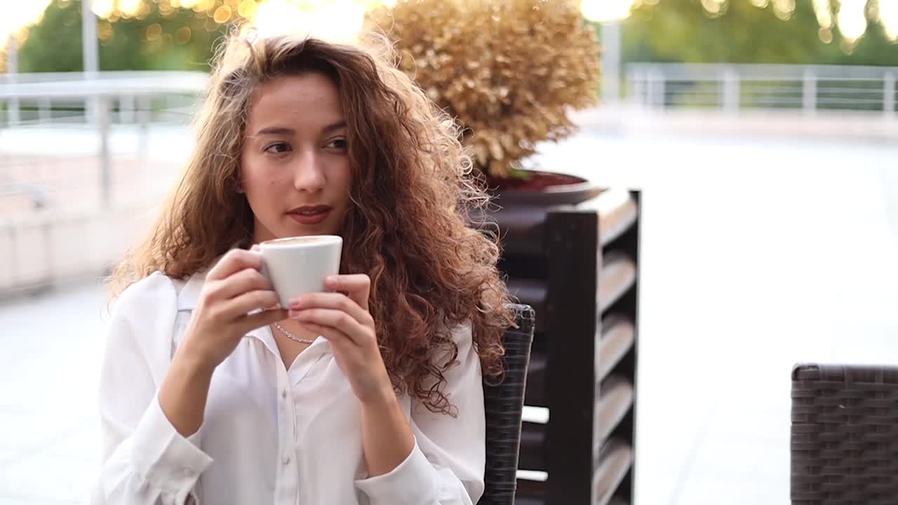 一位女士在咖啡馆里享受卡布奇诺视频素材