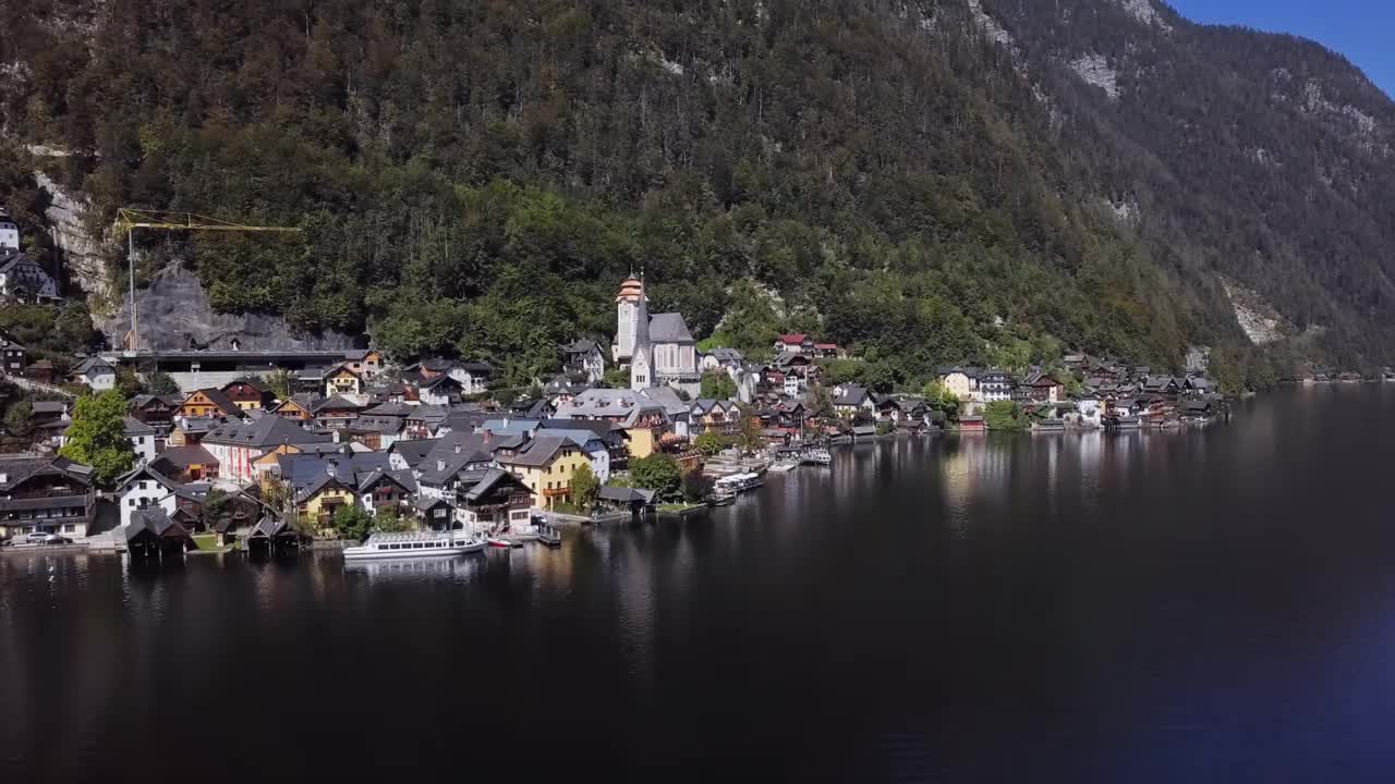 在阳光明媚的夏日早晨，在上奥地利州萨尔斯卡默古特的哈尔斯塔特村上空飞行，速度从24帧提高到2.5倍。视频素材