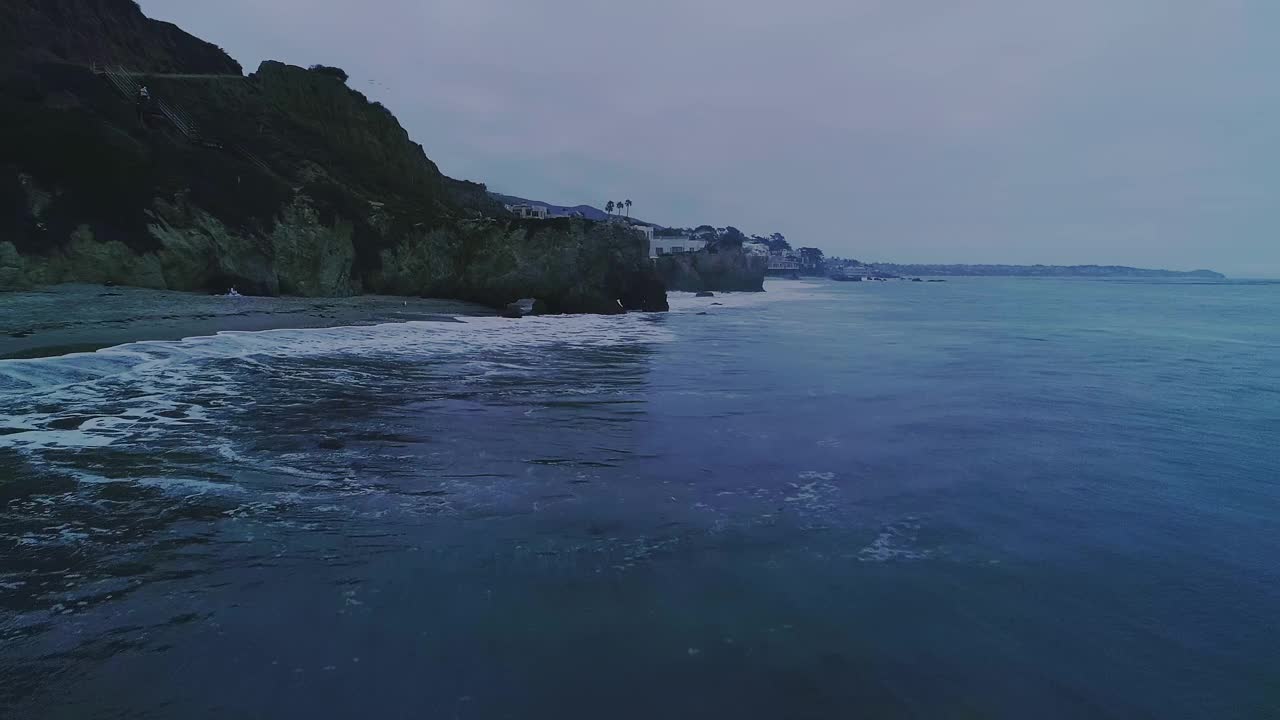 从空中轨道拍摄的马里布日落时的杜梅角海滩上的海浪视频素材