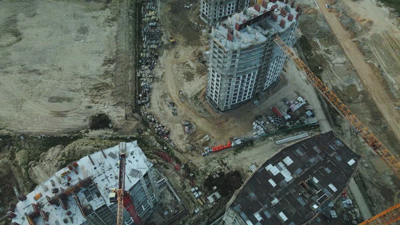 一个现代化城市街区的建筑工地。正在建设中的高层建筑。建筑塔式起重机。日落时的航空摄影。视频素材